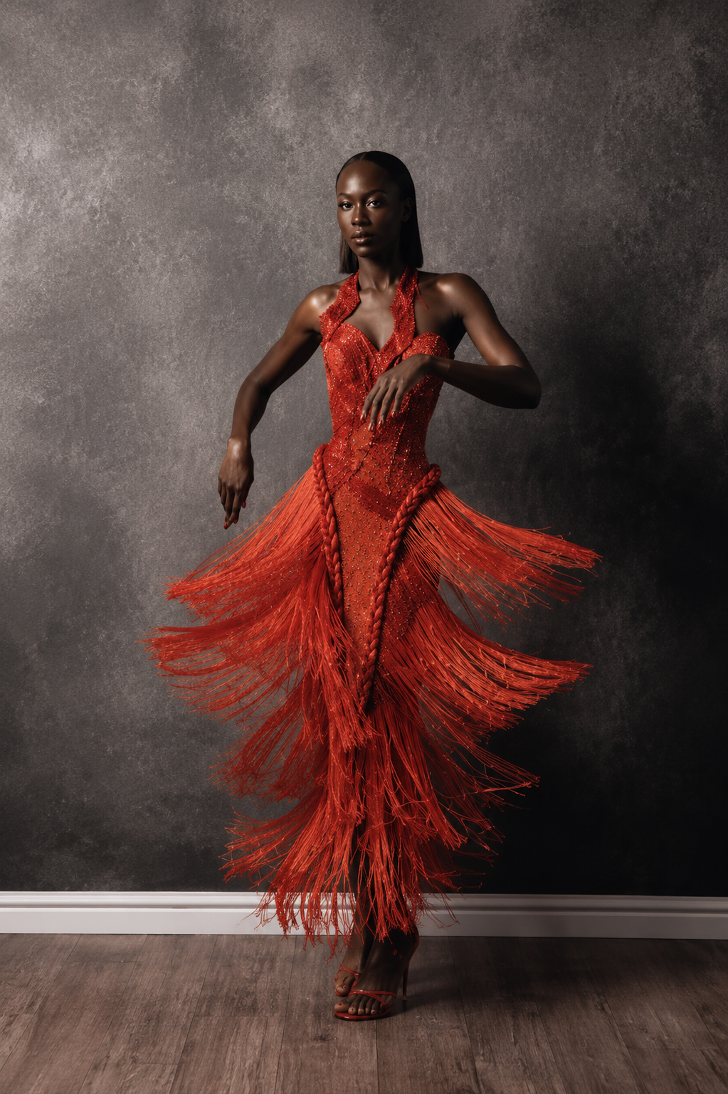 Red couture evening gown with cascading fringe details.